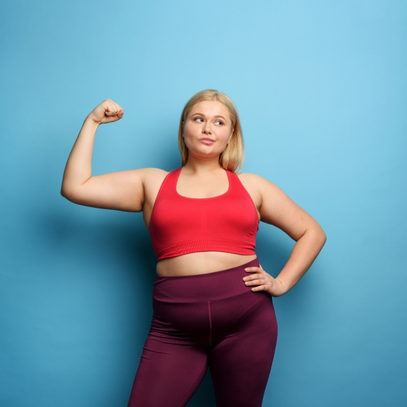mulher com sobrepeso mostrando o bíceps 